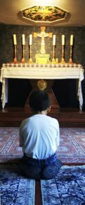 Enfant priant à la chapelle du centre d'accueil d'ANAK-Tnk